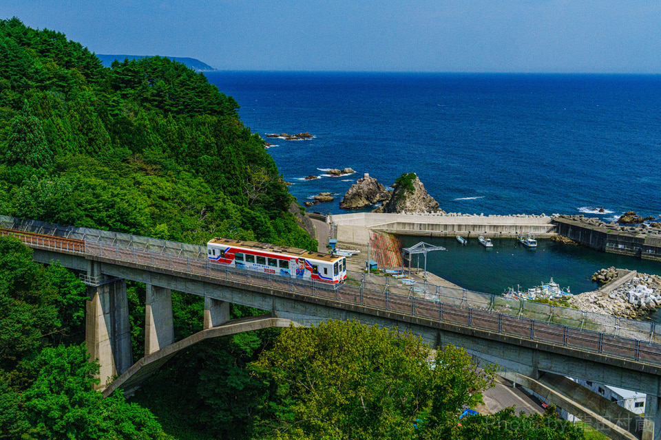 三陸鉄道北リアス線〈大沢橋梁〉
 堀内駅-白井海岸駅間にある鉄板の撮影地、天候にも恵まれ、美しい三陸の海と空を背景に撮影することができました。乗客の皆さんにこの絶景を楽しんでもらおうとしばらく停車してからゆったりと走り出しました。